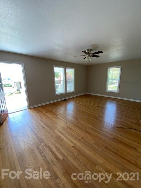 369 North Canton Road Canton, NC 28716 - Photo 10 of 21 an empty room with wooden floor and windows