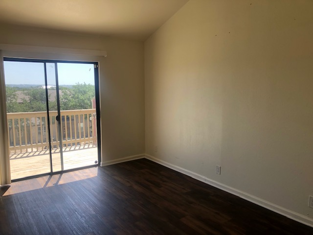 505 Demarett Drive, Unit 12 Point Venture, TX 78645 - Photo 14 of 15 a view of an empty room with wooden floor and a window