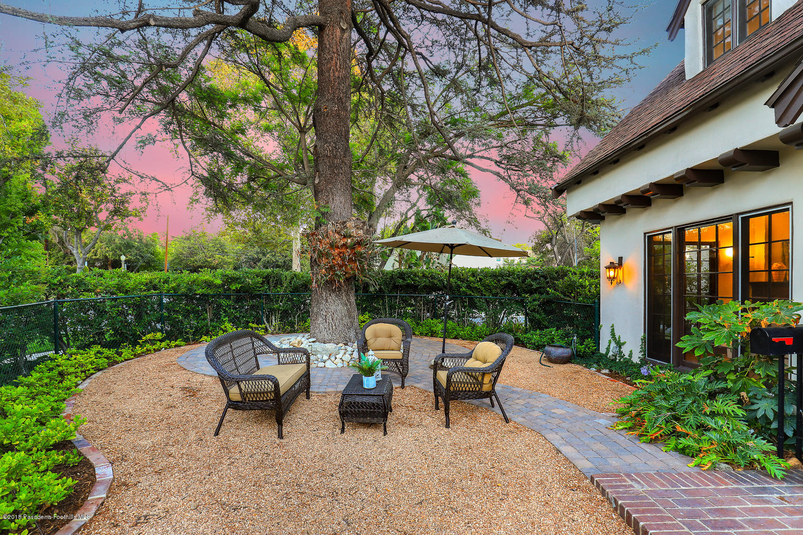 884 Old Mill Road Pasadena, CA 91108 - Photo 4 of 32 a view of a patio with table and chairs under an umbrella with a fire pit