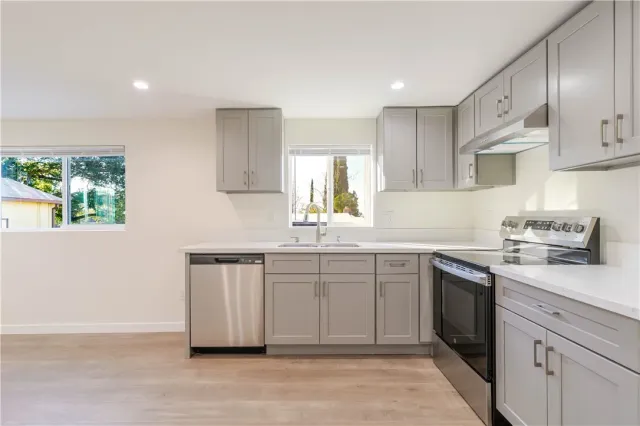 a kitchen with a sink cabinets appliances and a window