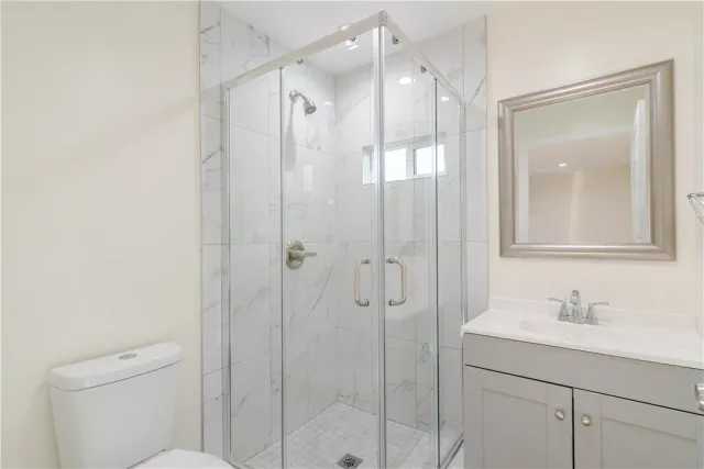 a bathroom with a shower sink vanity and mirror