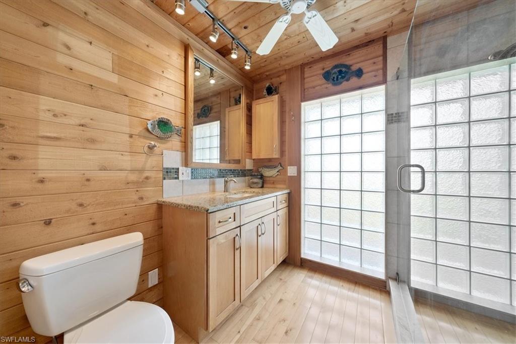 2997 Poplar Street Naples, FL 34112 - Photo 28 of 49 a bathroom with a granite countertop sink a toilet and a shower