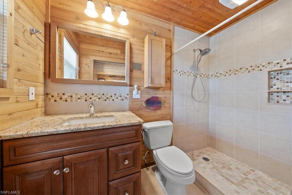 2997 Poplar Street Naples, FL 34112 - Photo 5 of 49 a bathroom with a granite countertop sink a toilet and shower