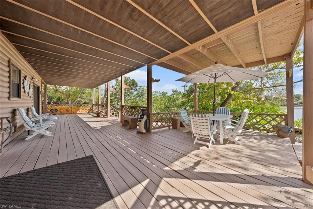 2997 Poplar Street Naples, FL 34112 - Photo 6 of 49 a view of a patio with table and chairs potted plants with wooden floor and fence