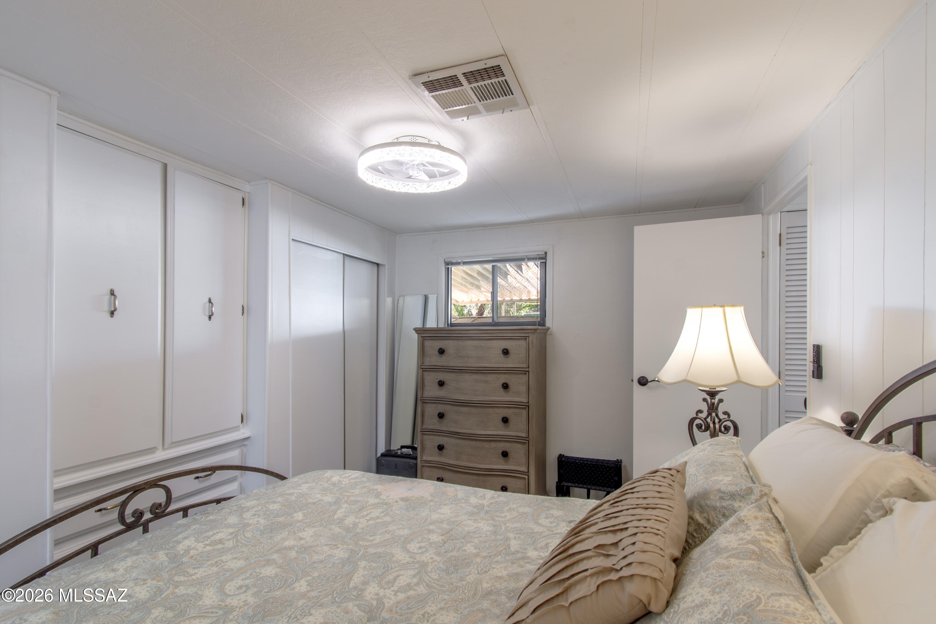 4550 North Flowing Wells Road, Unit 155 Tucson, AZ 85705 - Photo 18 of 40 a bedroom with a bed and a lamp