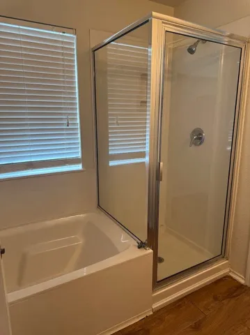 a bathroom with a shower and a bath tub