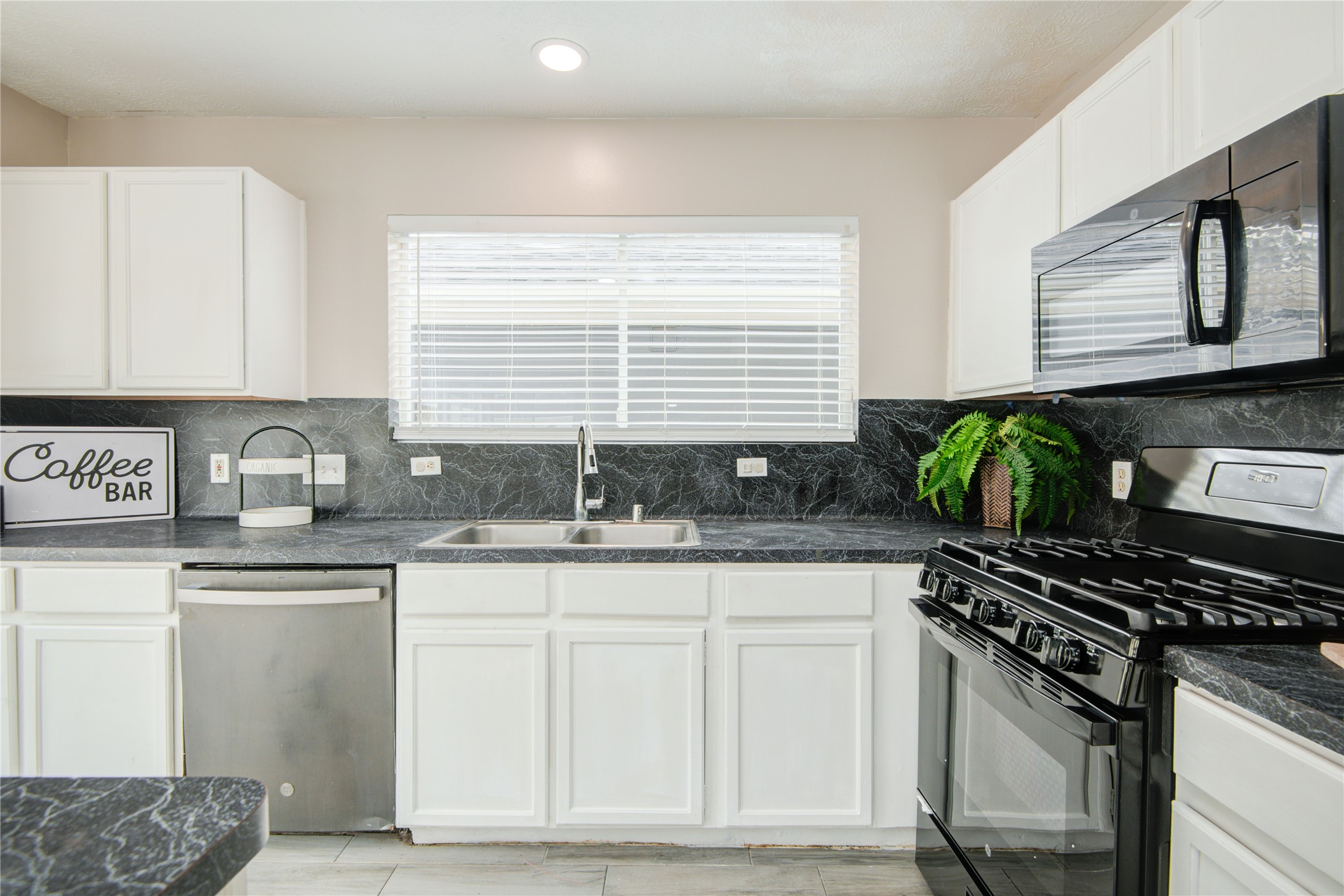 10023 Farrell Drive Houston, TX 77070 - Photo 12 of 26 a kitchen with granite countertop a sink stove and cabinets