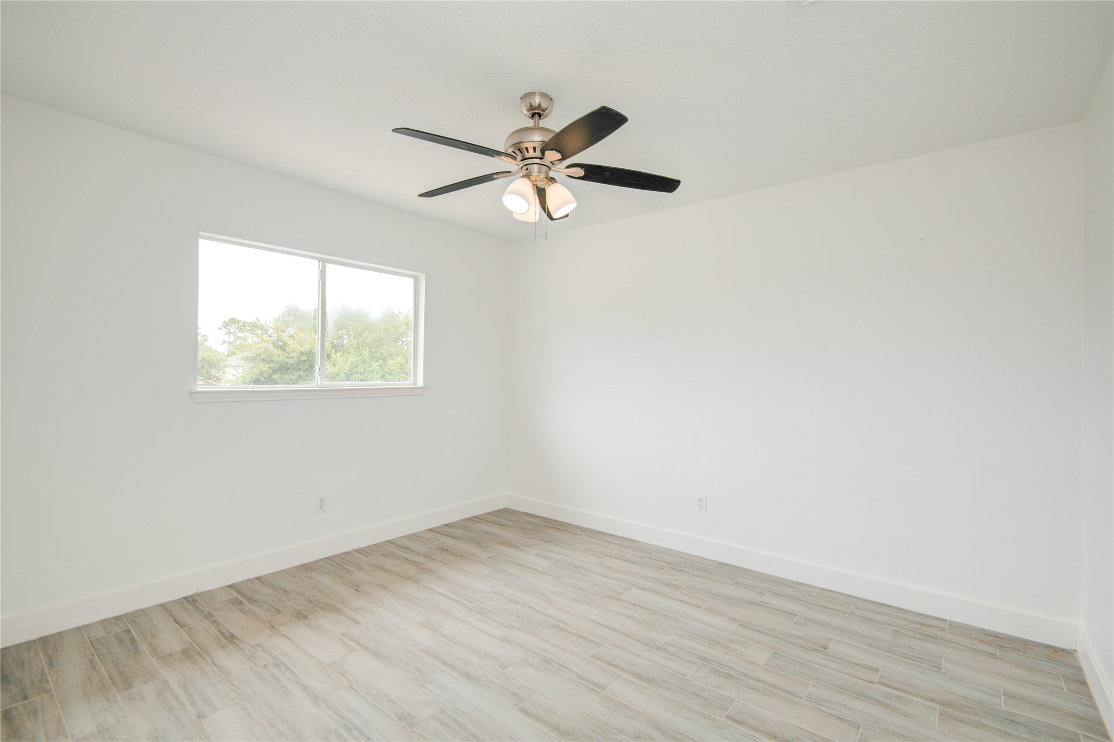 10023 Farrell Drive Houston, TX 77070 - Photo 23 of 26 an empty room with wooden floor ceiling fan and windows