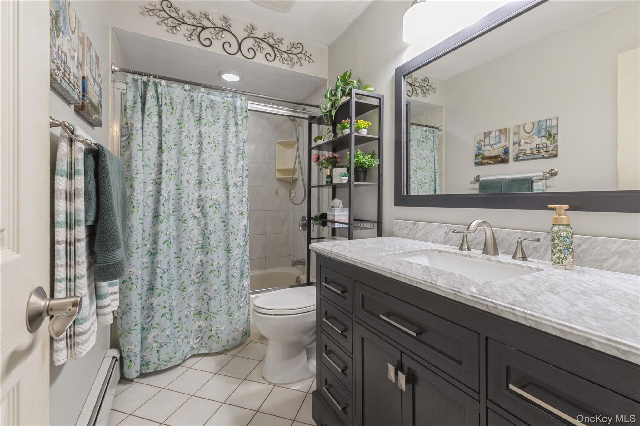 115 Clarendon Road Ronkonkoma, NY 11779 - Photo 15 of 45 Bathroom featuring a dark wood-finish vanity with a light countertop, a rectangular undermount sink, and a framed mirror