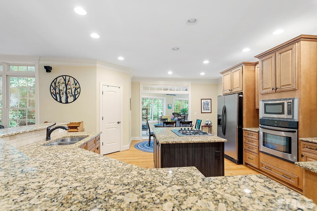 3102 Ringland Road Raleigh, NC 27613 - Photo 17 of 42 a kitchen with stainless steel appliances kitchen island granite countertop a refrigerator and a sink