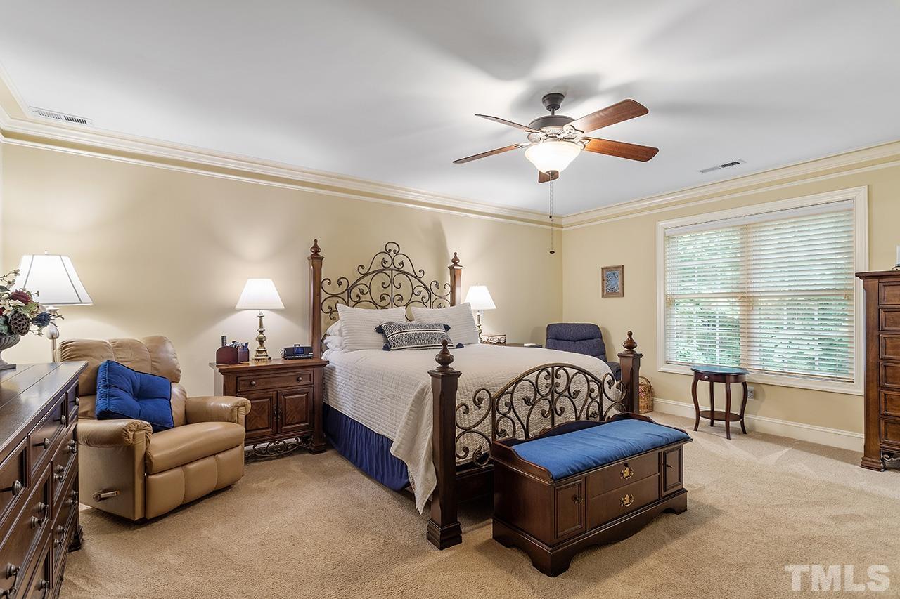 3102 Ringland Road Raleigh, NC 27613 - Photo 31 of 42 a bedroom with a bed couch chandelier and a window