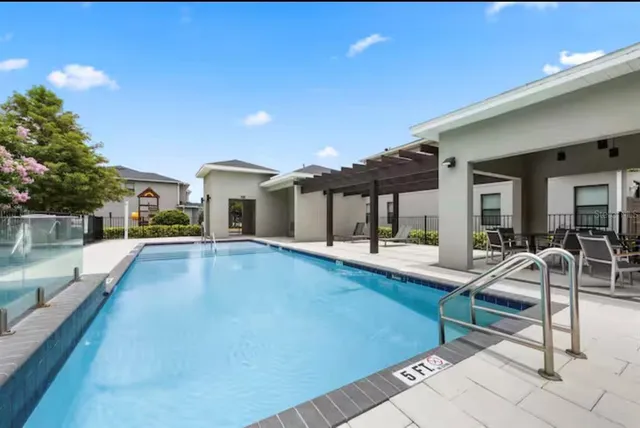 a view of a house with swimming pool and sitting area