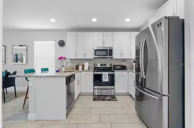 a kitchen with a refrigerator a sink and a stove top oven