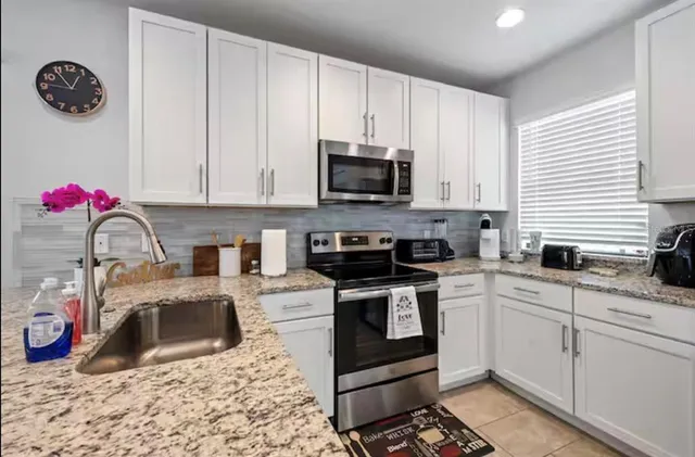 a kitchen with stainless steel appliances granite countertop a sink stove and cabinets