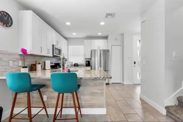 a living room with furniture and a kitchen