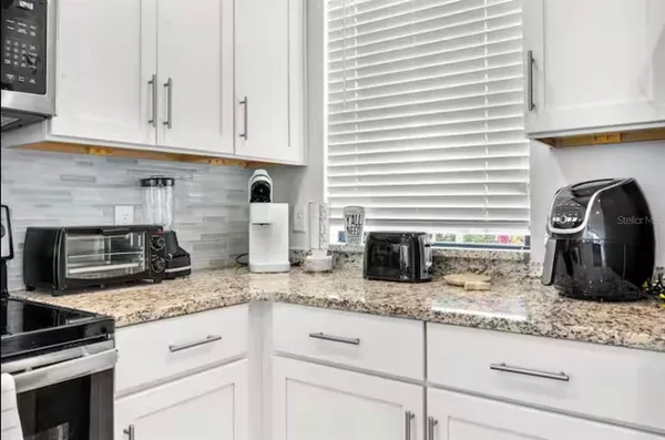 a kitchen with granite countertop a stove sink and cabinets