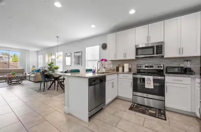 a kitchen with cabinets and chairs