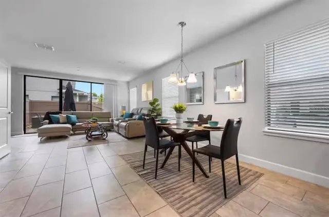 a view of a dining room and livingroom with furniture wooden floor a chandelier
