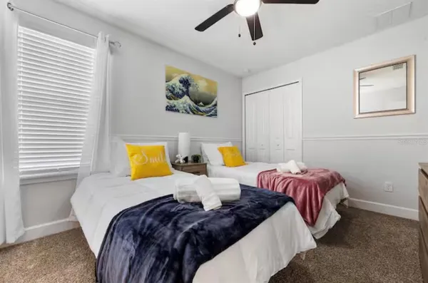 a bedroom with two beds and painting on the wall