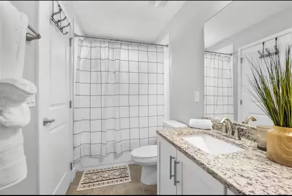 a bathroom with a granite countertop sink a toilet and a shower