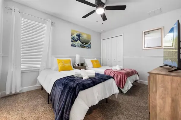 a bedroom with two beds and painting on the wall