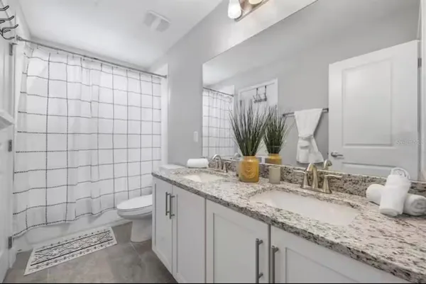 a bathroom with a granite countertop sink a toilet and a mirror