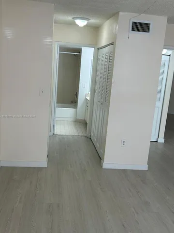 an empty room with wooden floor and a sink