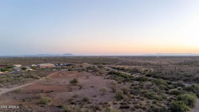 a view of a dry field with mountains in the background