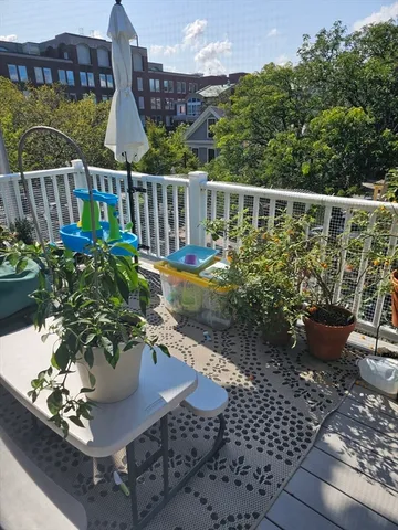 a view of a balcony with chairs potted plants