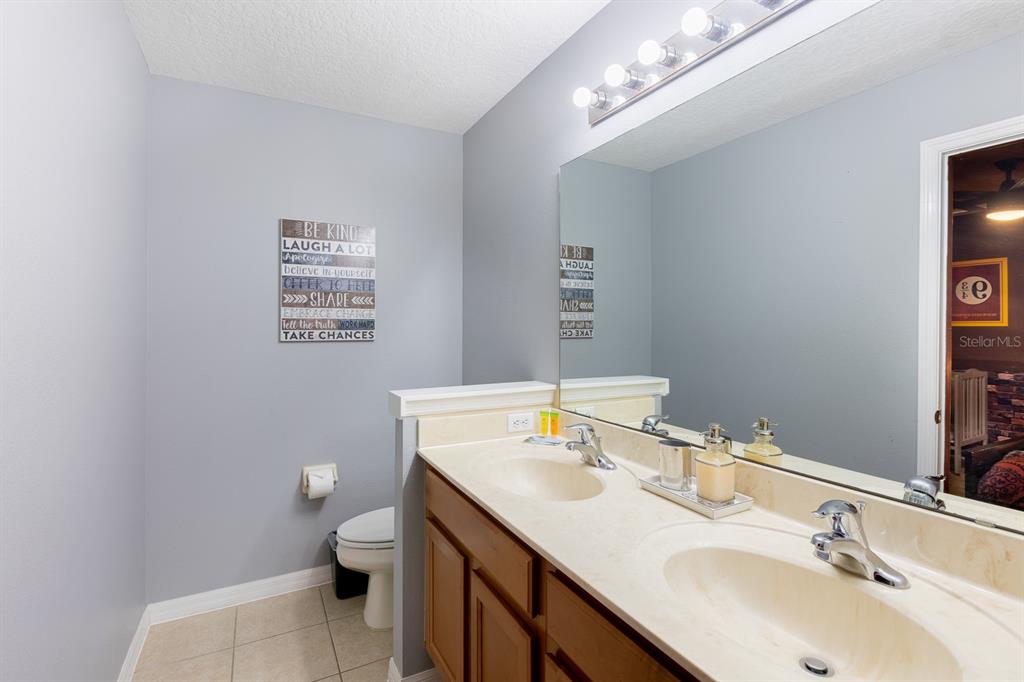 891 Assembly Court Reunion, FL 34747 - Photo 26 of 54 a bathroom with a sink a toilet and mirror
