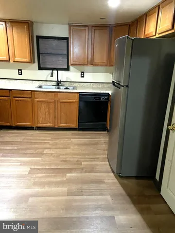 a kitchen with stainless steel appliances granite countertop a refrigerator a sink and a stove