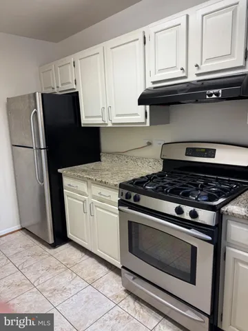 a stove top oven sitting inside of a kitchen