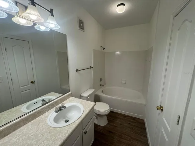 a bathroom with a sink double vanity granite toilet tub and shower