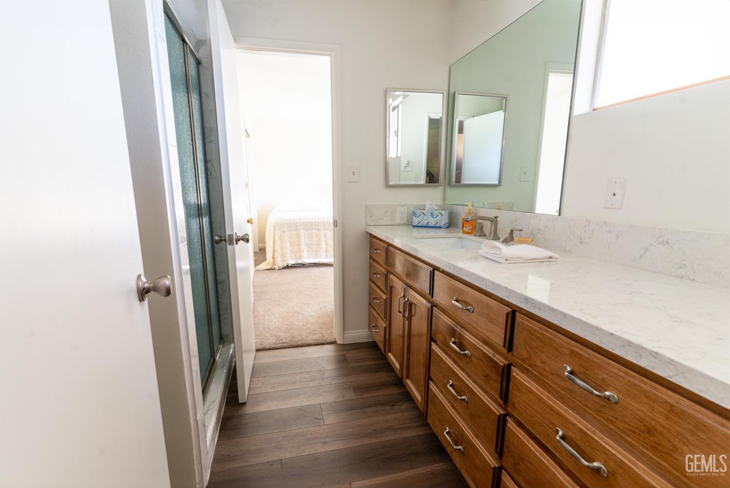 Undisclosed Address Bakersfield, CA 93308 - Photo 7 of 18 a bathroom with a double vanity sink and a mirror