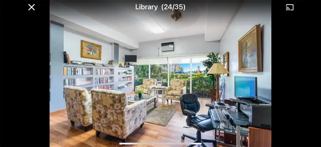 a living room with furniture a flat screen tv and a floor to ceiling window