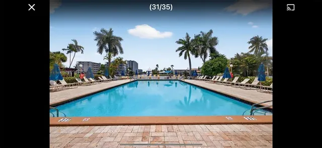 a view of swimming pool with outdoor seating and lake view