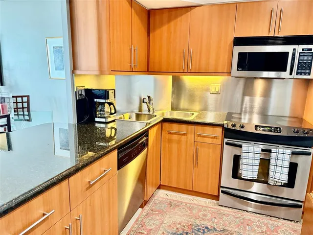 a kitchen with stainless steel appliances a stove a microwave and sink