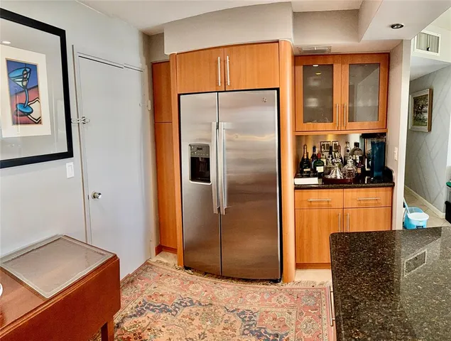 a kitchen with stainless steel appliances granite countertop a refrigerator and a sink