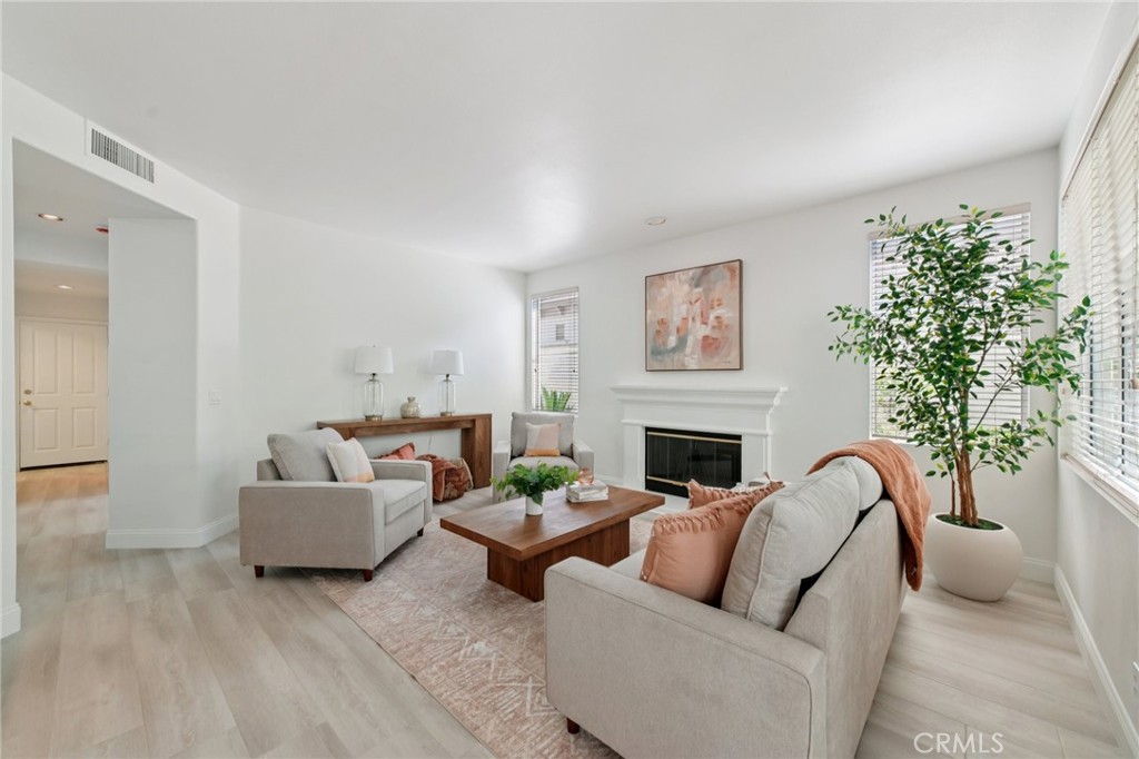 12440 Butler Way Tustin, CA 92782 - Photo 6 of 65 View of the family room with gas fireplace. Hallway on the left leads to the first level bedroom, full bath, laundry room w/sink and the spacious 3 car garage.