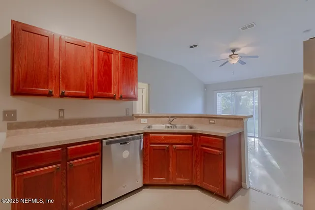 a kitchen with a sink dishwasher stove and cabinets