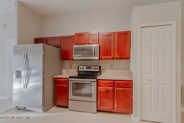 a kitchen with stainless steel appliances granite countertop a stove a refrigerator and a microwave