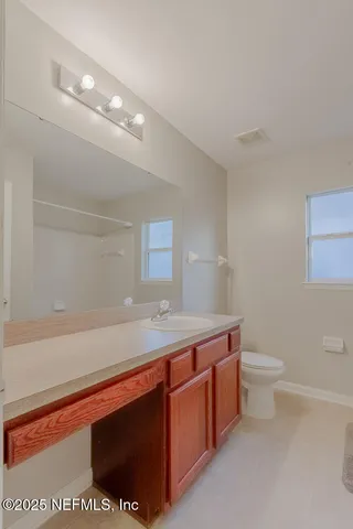 a bathroom with a sink a toilet and mirror