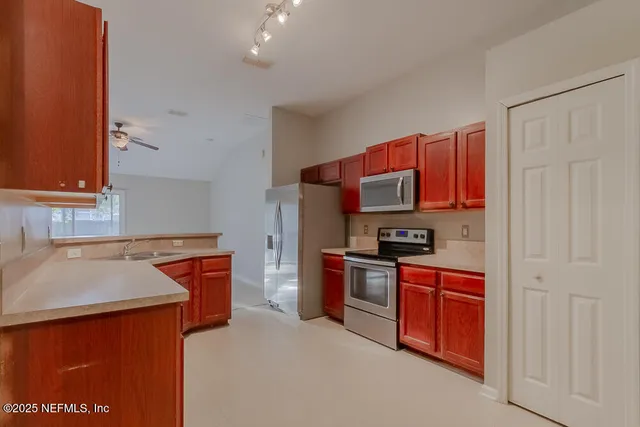 a kitchen with stainless steel appliances granite countertop a sink and a stove