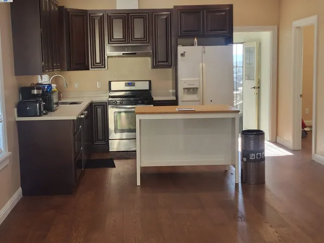 a kitchen with stainless steel appliances a refrigerator and a stove top oven