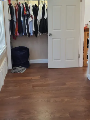 a view of walk in closet with clothes and shoes