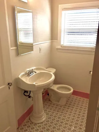 a bathroom with a sink toilet and a window