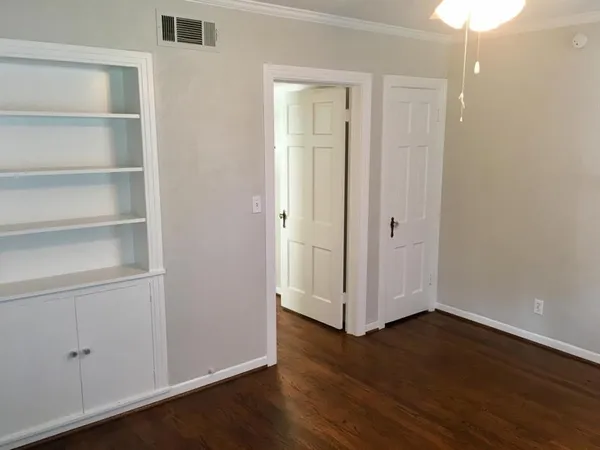 a view of an empty room with wooden floor