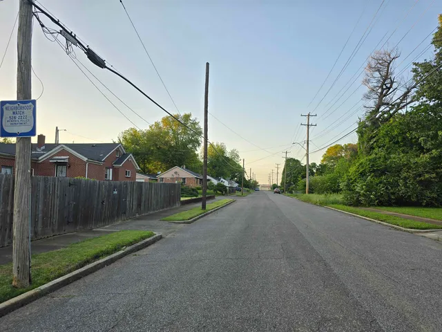 a view of a street with cars parked on the road