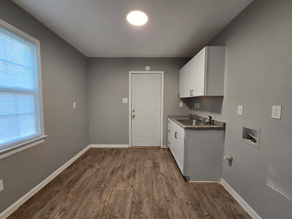 a kitchen with granite countertop wooden floors and white stainless steel appliances