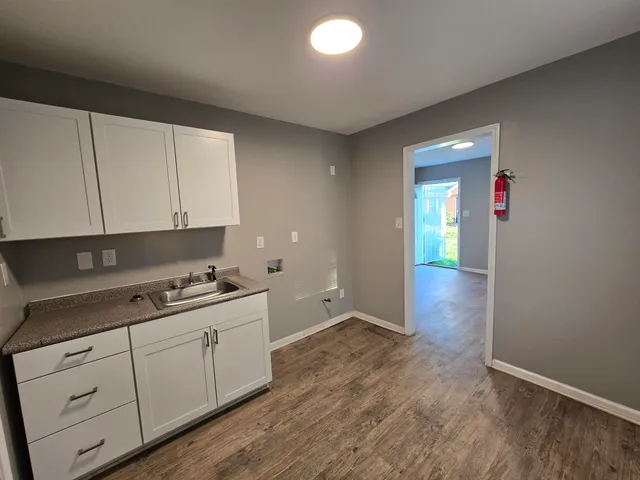 a kitchen with white cabinets and sink
